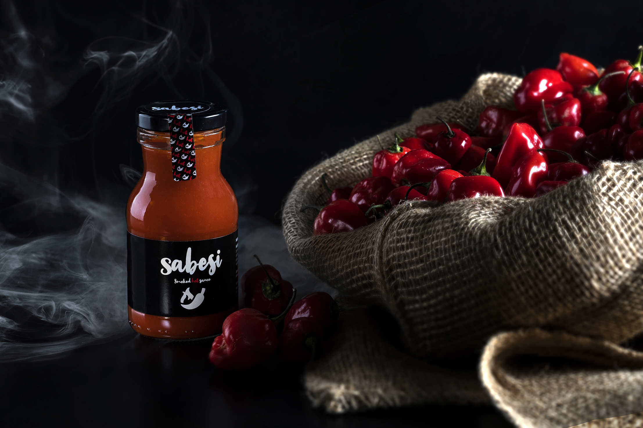 Sabesi con humo y ajíes habaneros sobre fondo negro